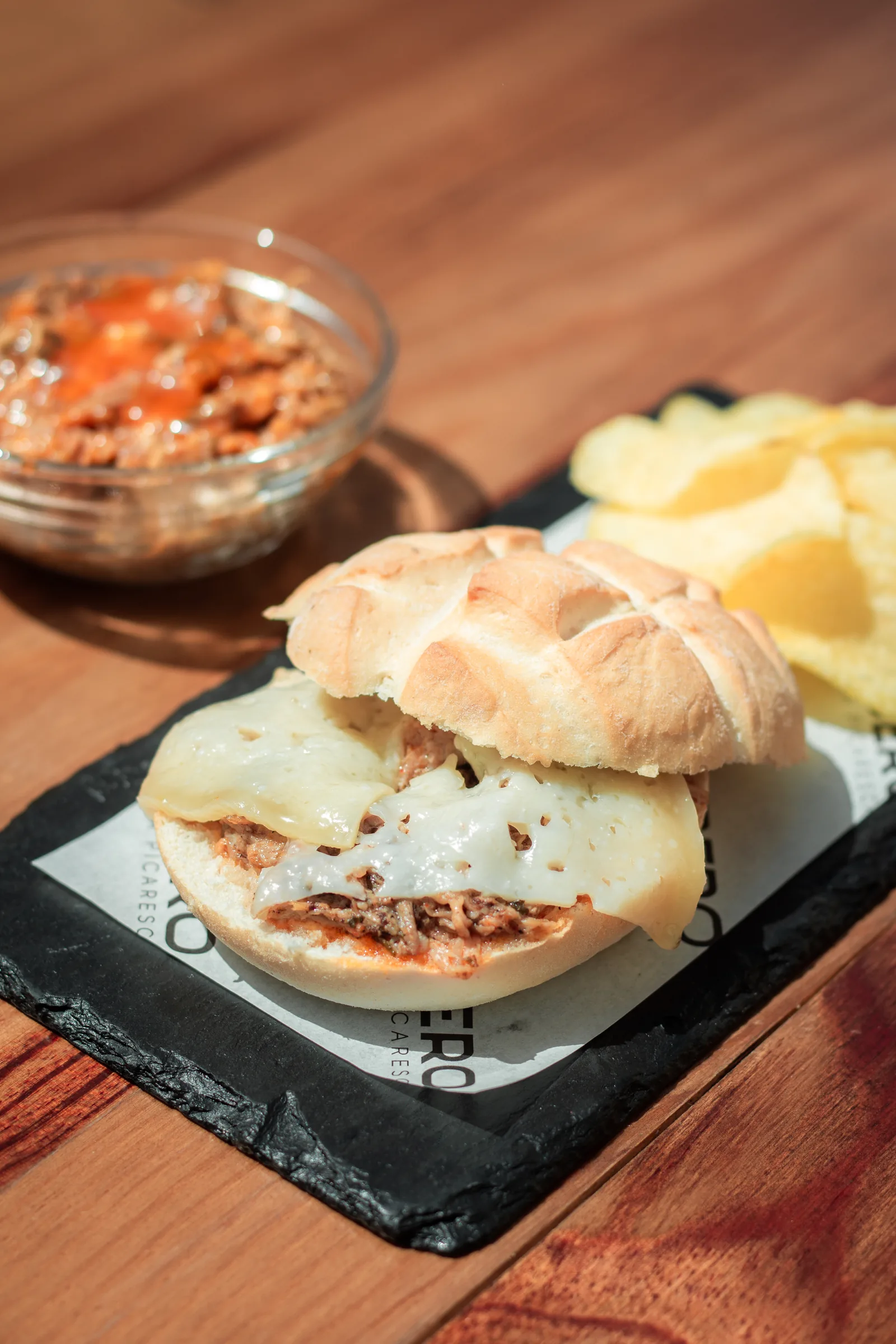 Montadito de pringá con queso, servido con patatas fritas